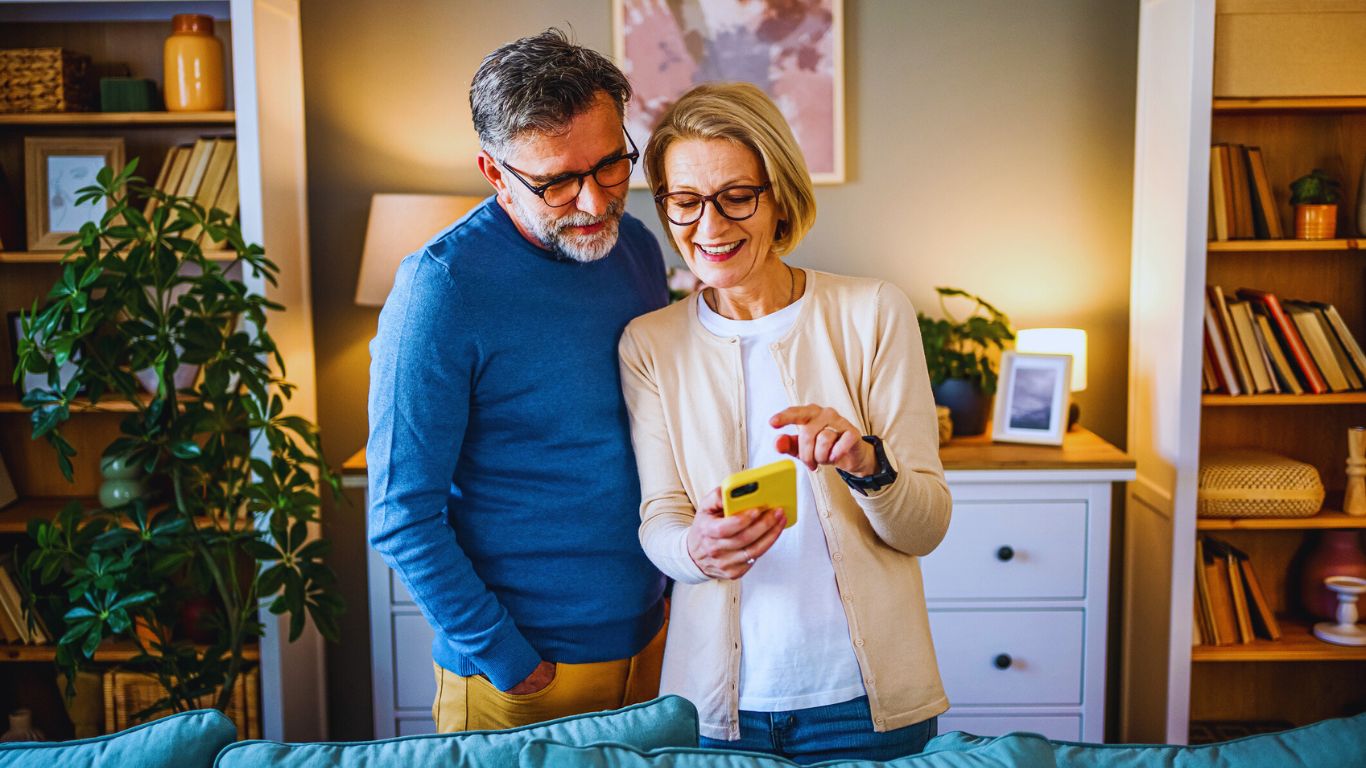 Financial Adviser South East Melbourne – couple discussing plans while checking mobile